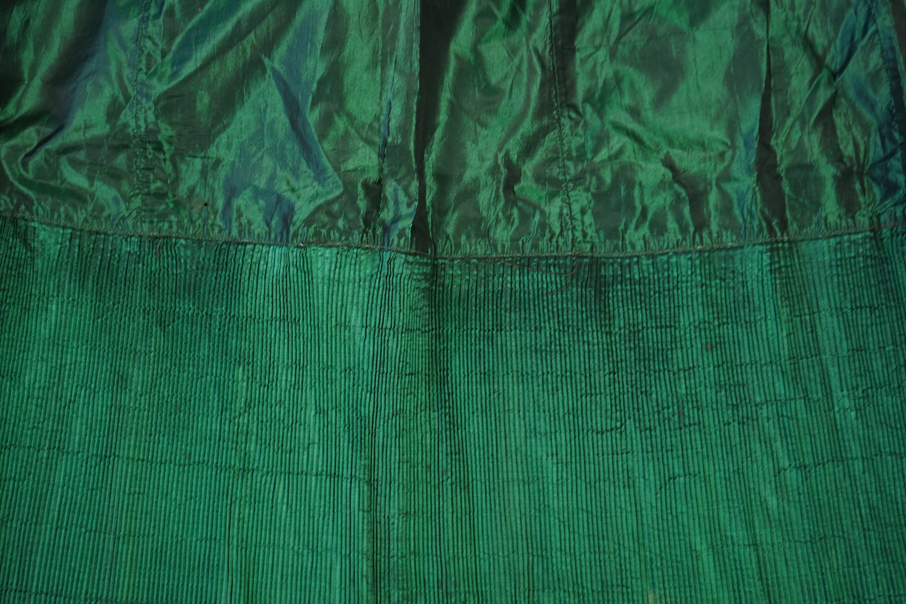A flesh coloured 1930s lace evening dress and matching jacket together with a bottle green velvet evening dress and buckle belt and an unusual green shot silk pleated under skirt. Lace dress bust 32 inches. 156cm long. C